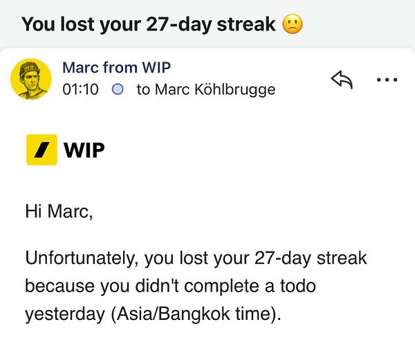 Photo of a hand holding an iPhone displaying the iOS home screen with various app icons and a scenic wallpaper.