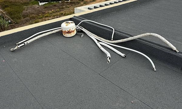 The image depicts a disorganized collection of discarded materials on a flat roof.