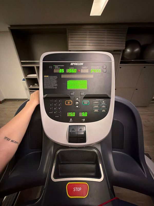 A black and white photograph of a man performing a squat exercise with a heavily loaded barbell in a gym setting.