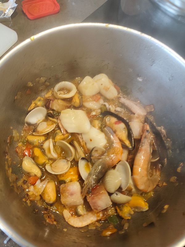 A man and woman hiking with backpacks on a green forest trail in the daytime.