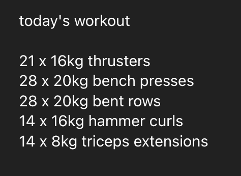 A woman performs a deadlift in a home gym with various exercise equipment and storage items visible.