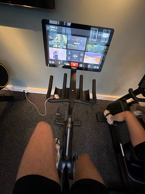 Photo of a gym workout area with various exercise equipment including weights and cardio machines.