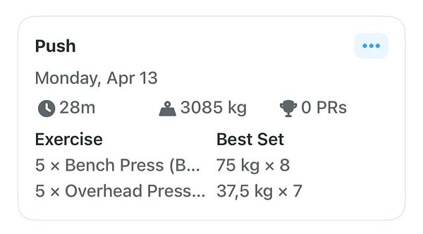 Gym workout area with various weightlifting equipment including a bench, squat rack, and kettlebells.