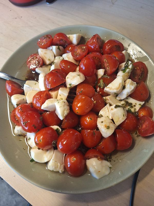 Overhead view of a plate with a snack of sandwiches and chips on a wooden table.