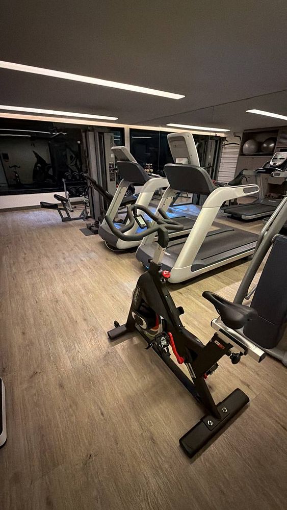Photo of a hotel gym in Brazil showing exercise equipment and gym setup for a remote personal training video call.