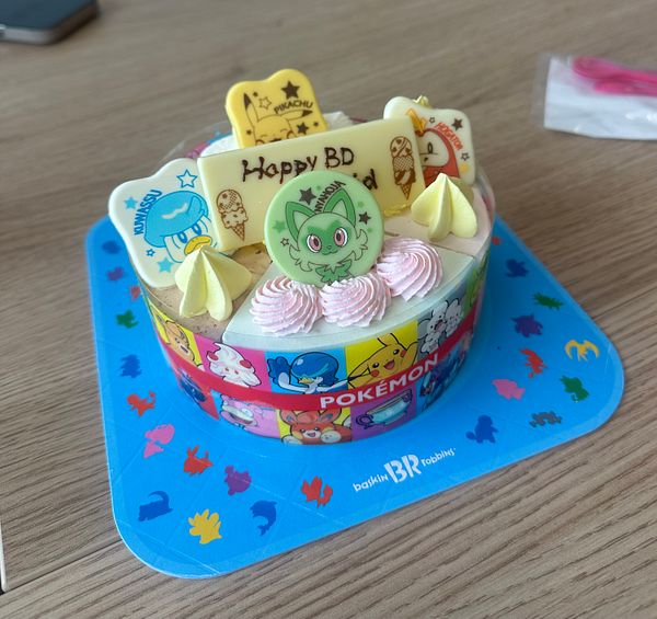 A colorful birthday cake decorated with Pokémon-themed elements.