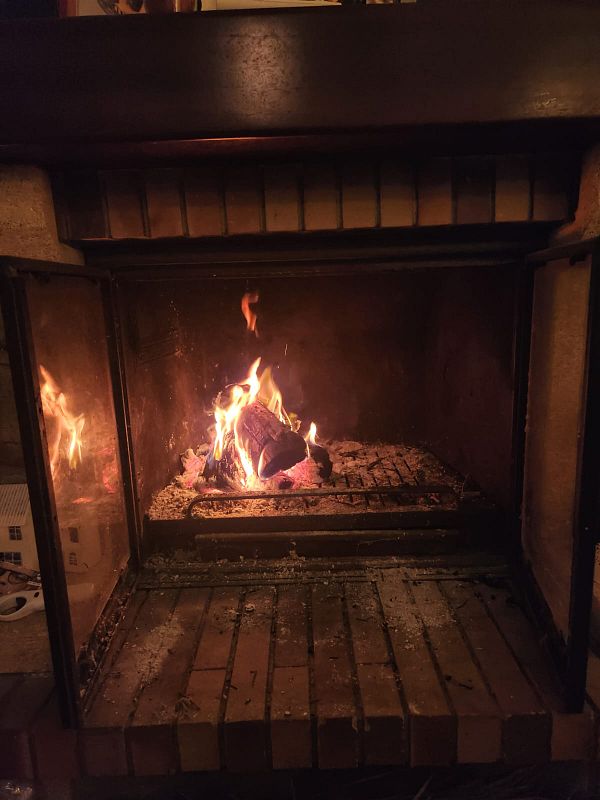 A cozy fireplace with a crackling fire and glowing embers.