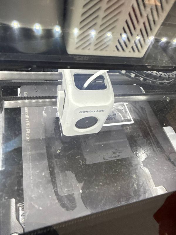 A 3D printer in action, creating a mount for a computer.