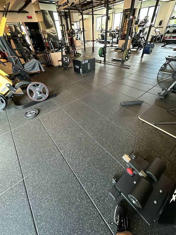 A well-equipped gym space featuring various workout equipment and weights.