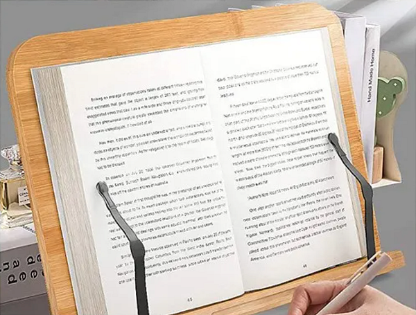 A wooden book stand holds an open book, showcasing its pages and reading accessories.