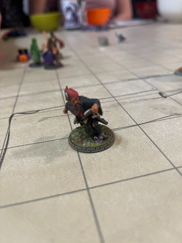 A detailed miniature figure of a knight is positioned on a grid-based game board.