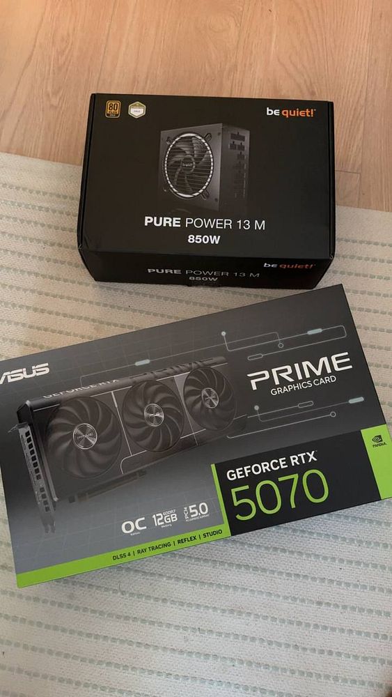 A gaming PC setup featuring a custom-built desktop tower with linear RGB lighting and a gaming keyboard.