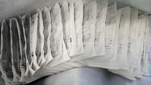 A collection of sealed Invisalign trays is neatly arranged in a container.