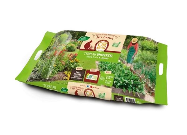 Large bag of universal potting soil labeled 'Universal Potting Soil 80L Ready to Use' placed on a tiled floor next to a bottle of household cleaner.