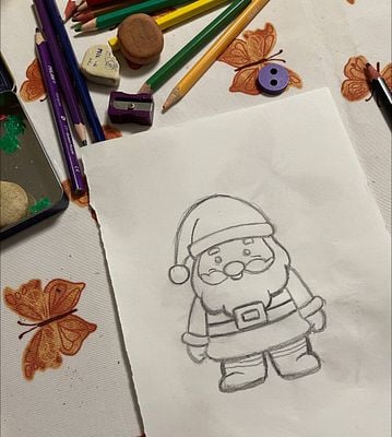 A playful scene featuring a hand-drawn Santa sketch surrounded by art supplies.