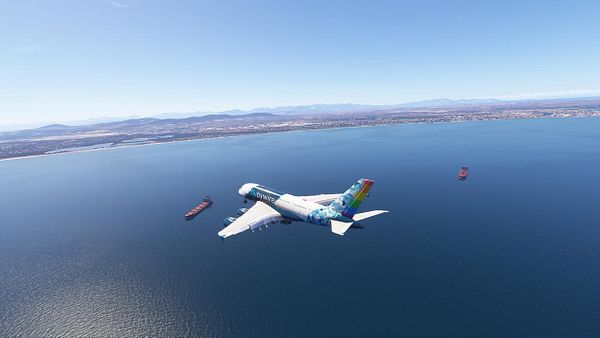An airplane flies over the ocean near Cape Town, with cargo ships visible below.