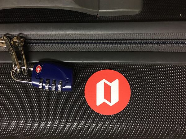 A suitcase featuring a combination lock and a prominent red logo.