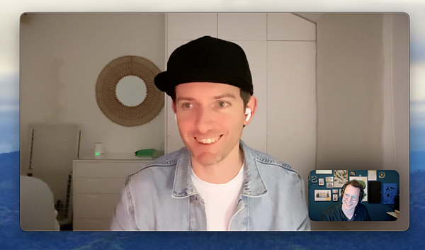 Two individuals are engaged in a video call, with one person smiling and the other appearing amused.