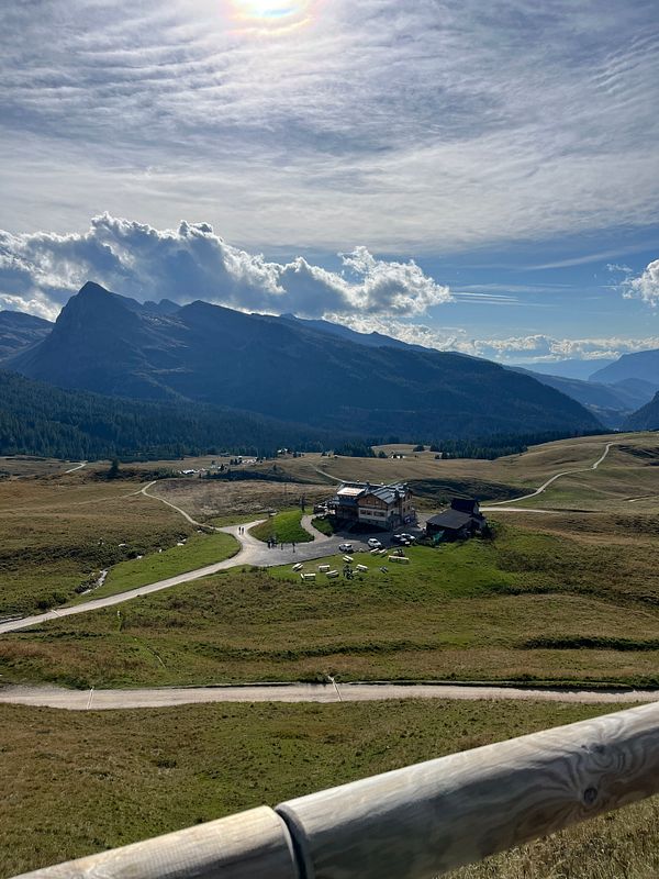 A scenic view of a mountainous landscape with a lodge and winding paths.