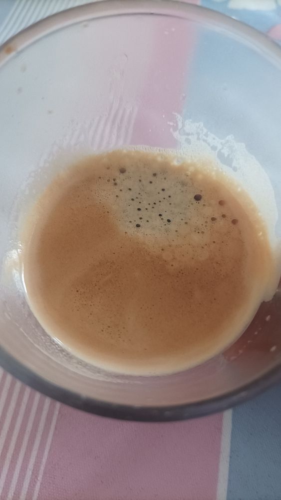 A close-up view of a glass containing freshly brewed espresso.
