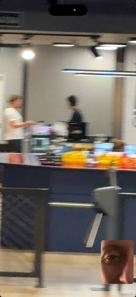 Photo of a muscular man shirtless at the gym, taking a selfie with a smartphone in front of a wall mirror.