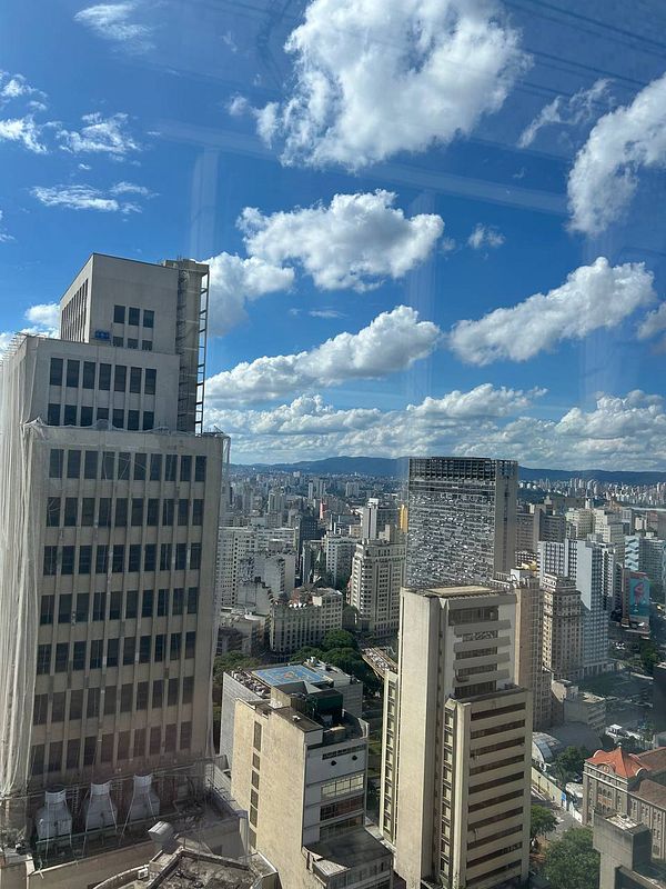 Colorful metal letters spelling 'PAULISTA' attached to a textured concrete wall outside a building.