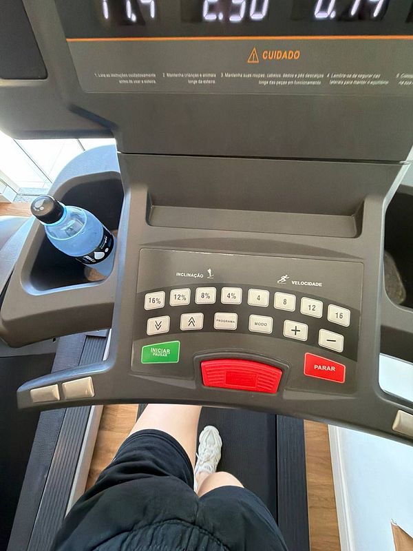 Muscular man lifting a barbell in a gym setting.