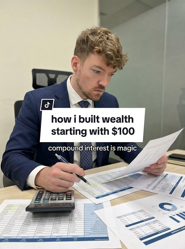 A man in a suit analyzes financial documents at a desk, emphasizing wealth-building strategies.
