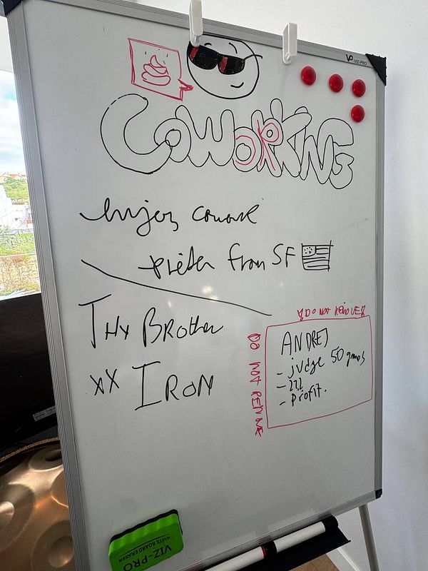 A whiteboard filled with notes and doodles related to a coworking event.