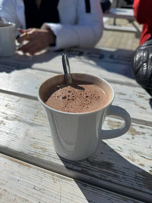 A close-up of a cup of hot chocolate on a wooden table.