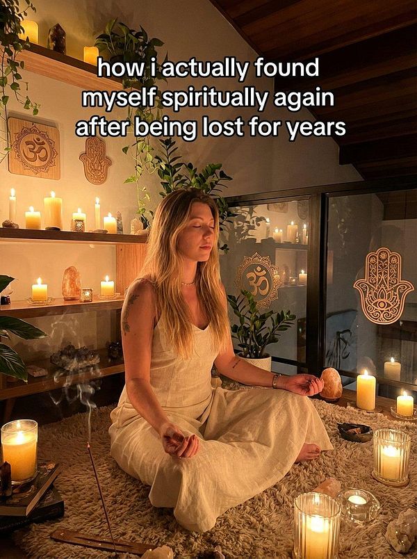 A woman meditates in a serene, candlelit environment filled with spiritual decor.