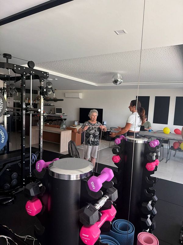 A woman performs strength training with a weighted barbell in a gym.