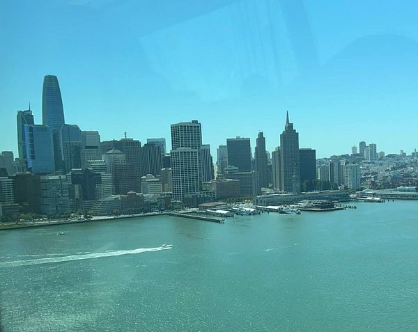 A panoramic view of the San Francisco skyline with the bay in the foreground.