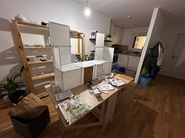 A workspace is set up with a prototype stand design for an upcoming convention.