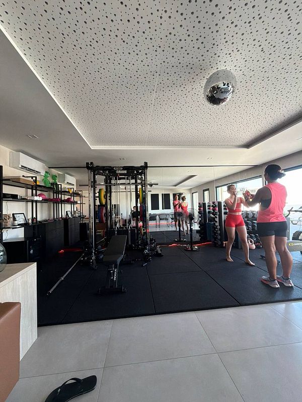 Photograph of a modern gym interior with workout equipment and mirrors.