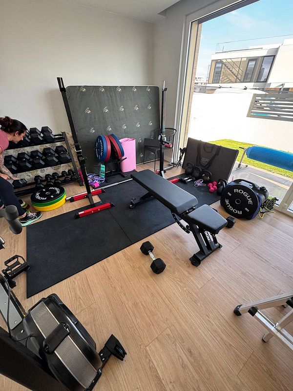 A home gym setup featuring various weights and exercise equipment.