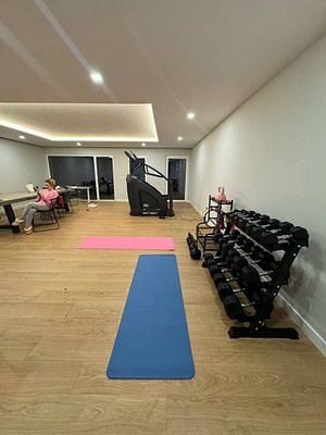 A partially completed home gym featuring exercise equipment and workout mats.