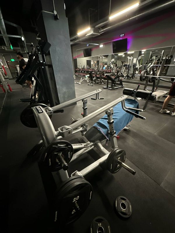 A gym interior featuring various workout equipment and weights.