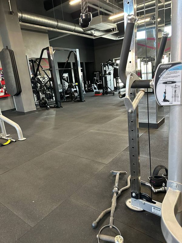 A well-equipped gym interior featuring various exercise machines and weights.