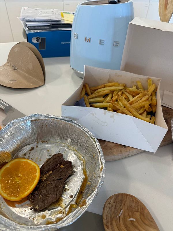A meal featuring picanha and fries is displayed on a kitchen table.