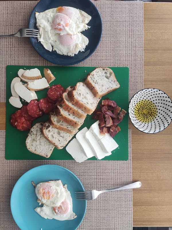 A delicious Sunday lunch spread featuring bacon, eggs, cheese, and bread.