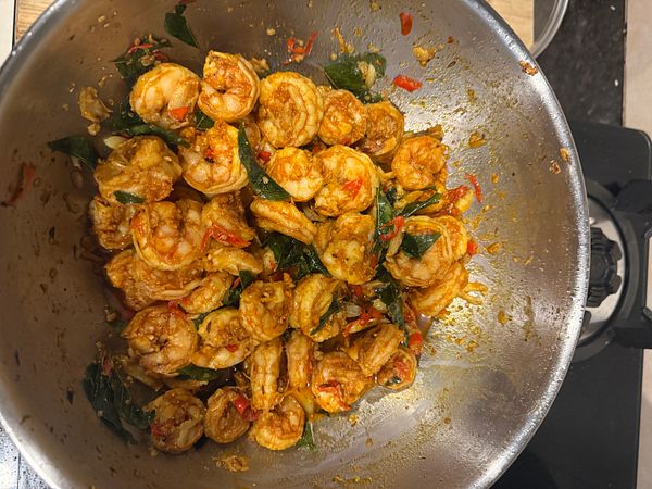 A bowl of cooked sea prawns mixed with spices and herbs.