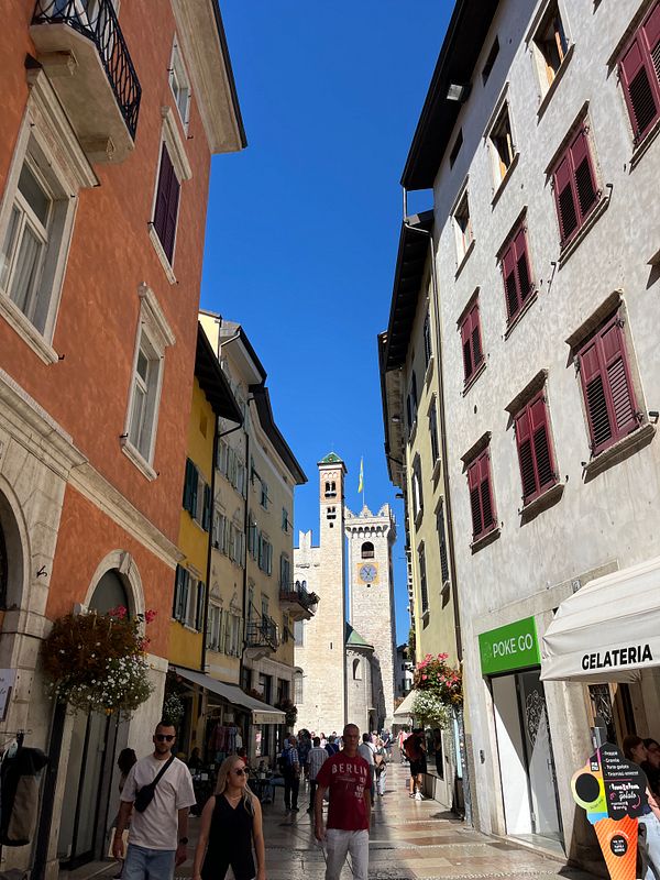A vibrant street scene in Trento, Italy, showcasing historic architecture and lively pedestrians.