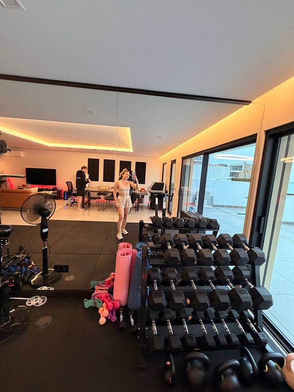 Photo of a man in a gym performing a workout using a lat pulldown machine.