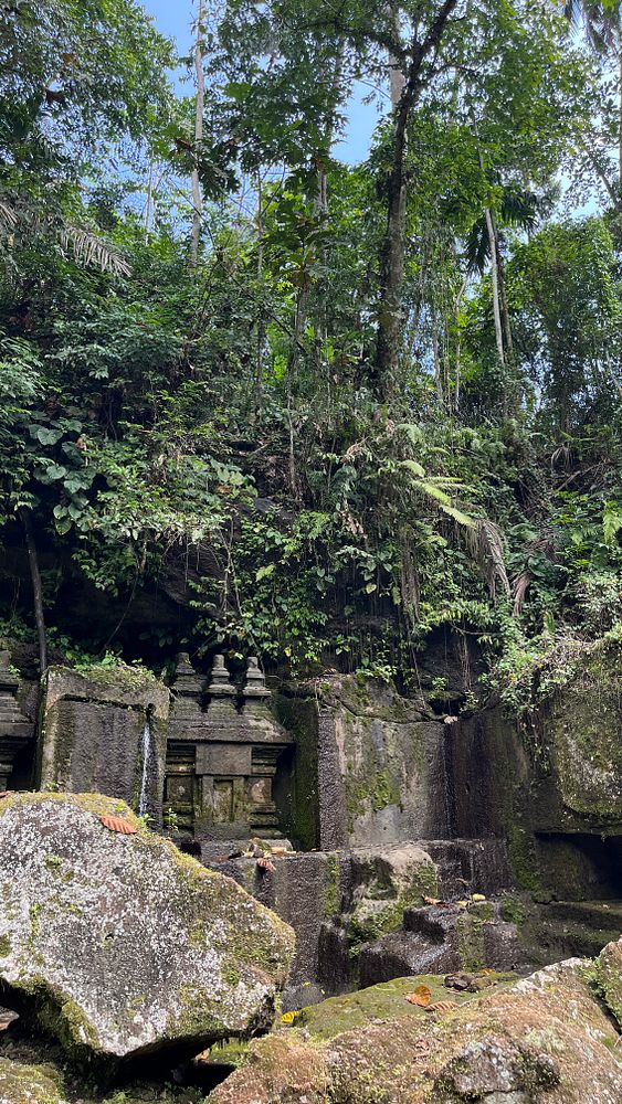 A lush, green landscape featuring ancient stone structures partially covered in moss.