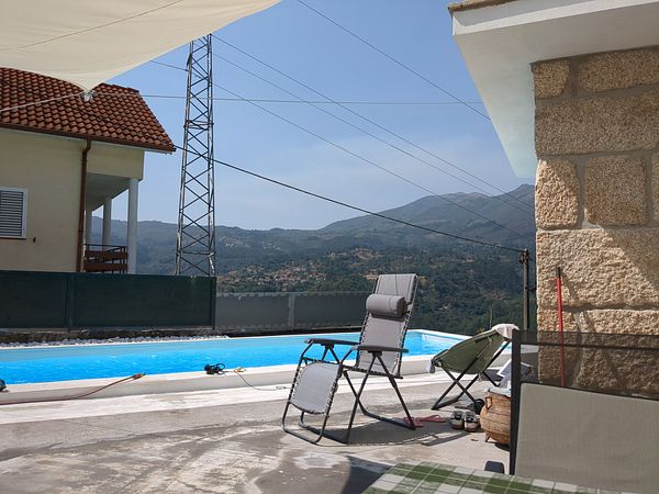 A serene outdoor setting featuring a swimming pool with a mountain backdrop.