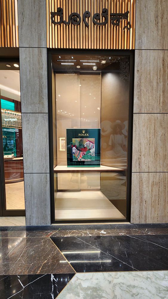 The image captures the exterior of a Rolex boutique showcasing a vibrant display.