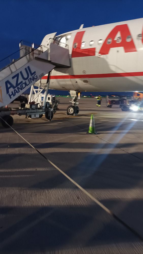 An airplane is being prepared for boarding at an airport during twilight.