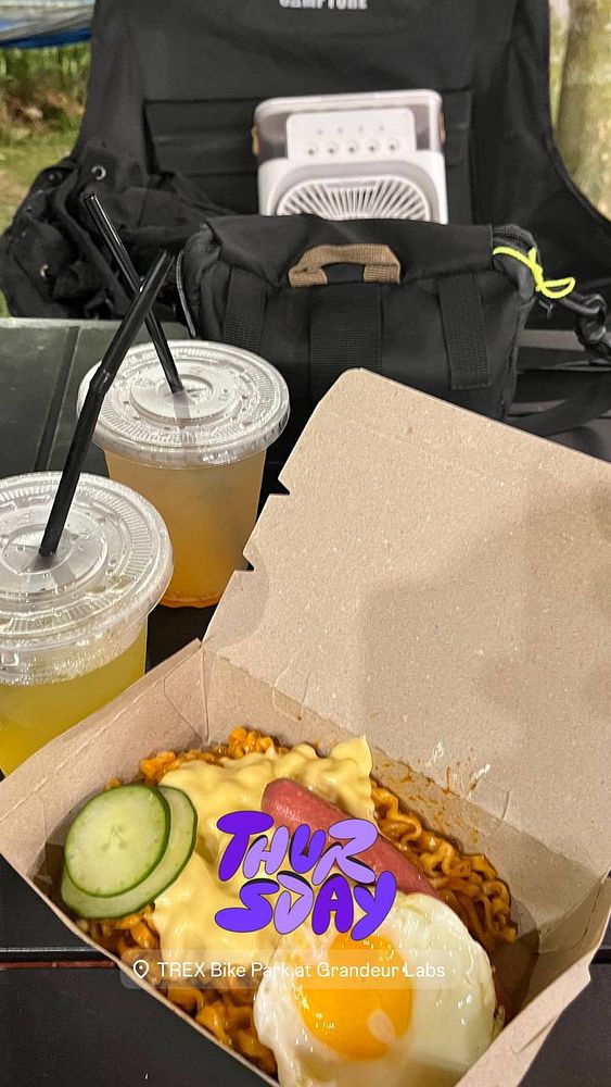 A meal featuring carbonara-style noodles is presented alongside drinks in a casual outdoor setting.