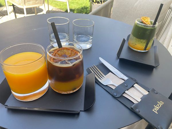 The image features a table setting with specialty drinks and utensils.
